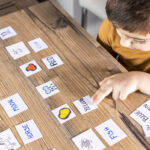 Little kid playing with cards of words and pictures.